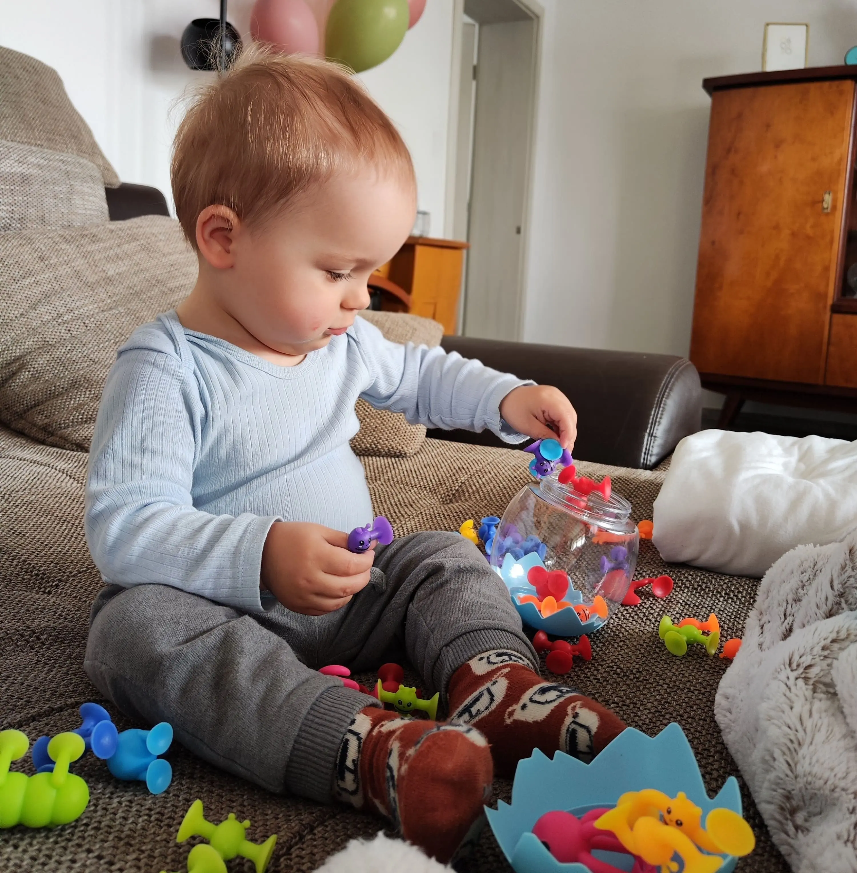 Kleinkind spielt mit Saugfiguren